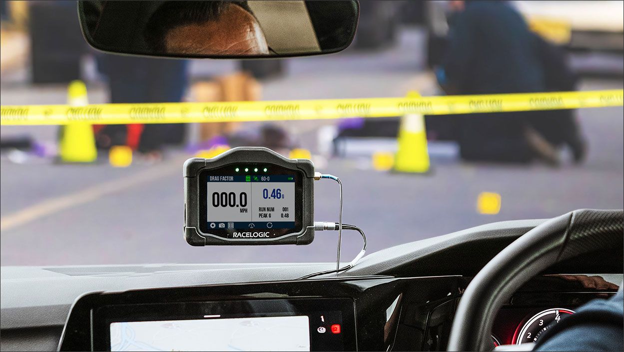 Officer measuring drag factor (coefficient of friction) with VBOX Roadside Kit in patrol car